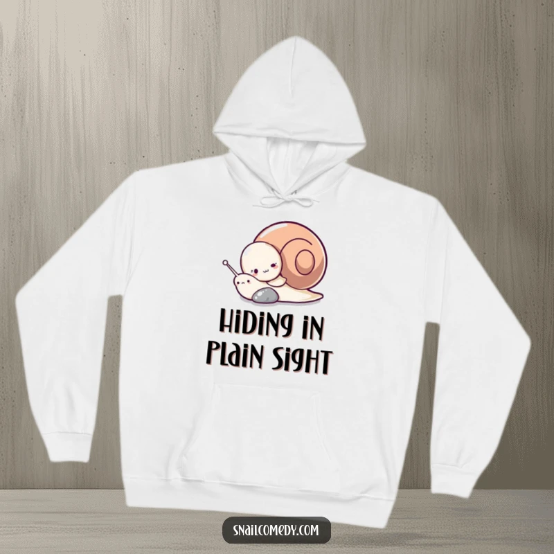 Funny hoodie with a playful snail character using a pebble as a hiding spot, creating a sense of cute mischief.